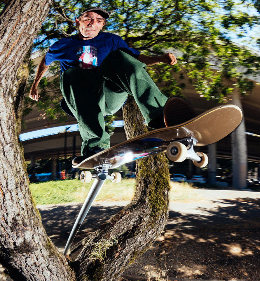 Polar skateboards pro in wallye tra gli alberi con lo skateboards