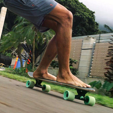 rider su longboard carving con ruote verdi per spiegare controllo stabilità e comportamento della tavola sotto pressione